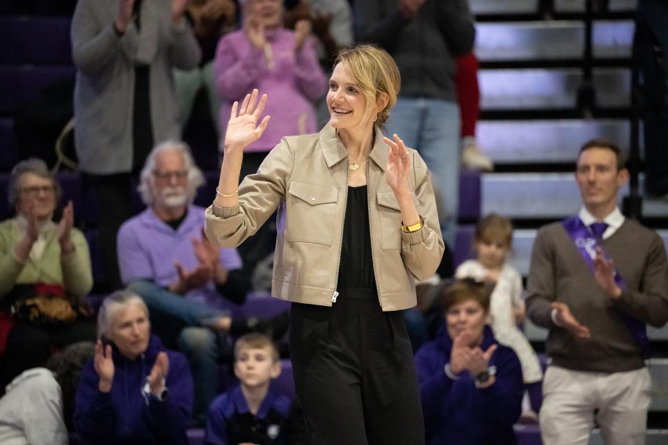 Kathleen Courtney waves to the crowd during Saturday's ceremony retiring the numbers of former Holy Cross female basketball players.