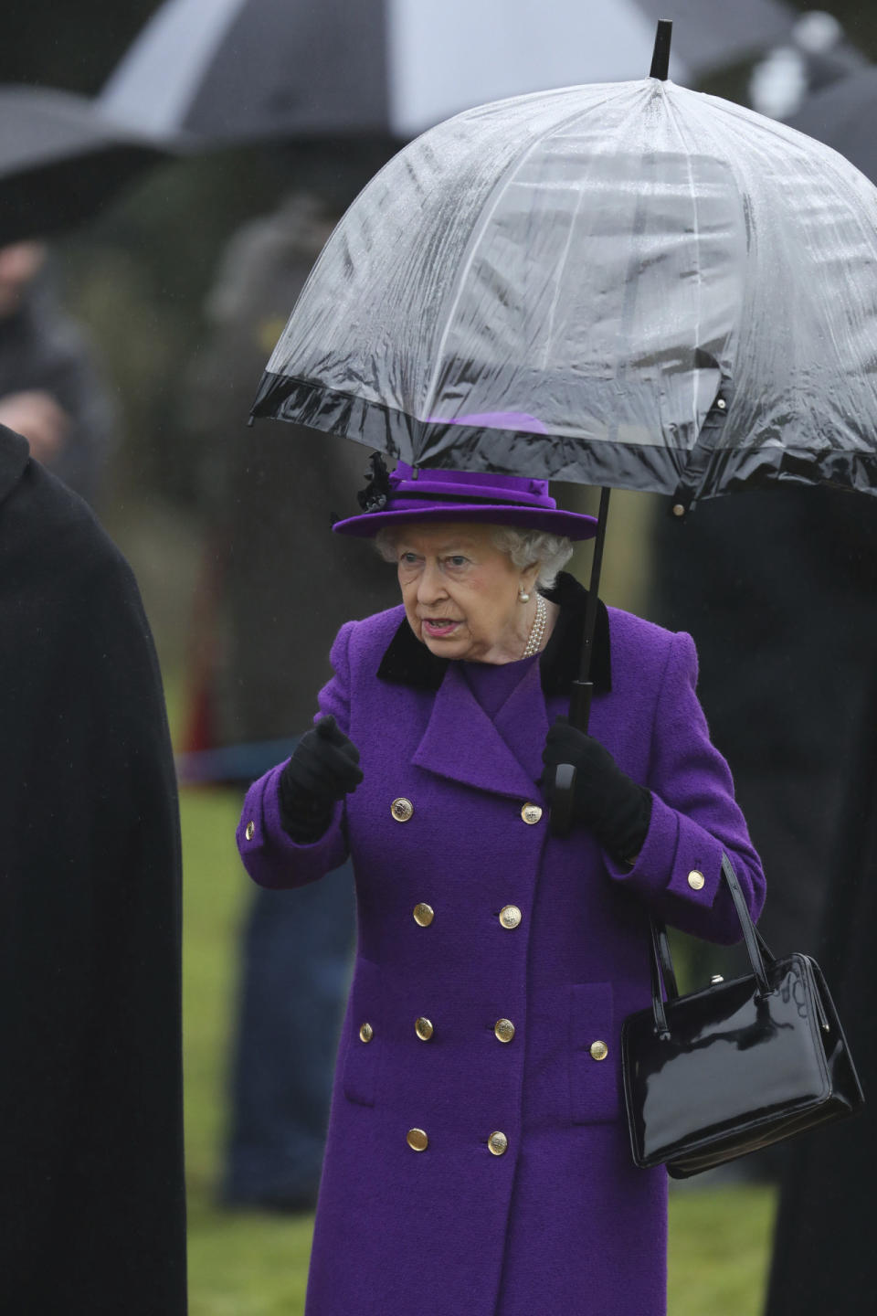 Wird die Handtasche, so heißt es, auf einem Tisch platziert, anstatt am Arm zu baumeln, oder wechselt die Queen den Taschenarm, so ist das hingegen ein Zeichen nicht ganz so dringlicher Langeweile. (Bild-Copyright: Chris Radburn/Associated Press)