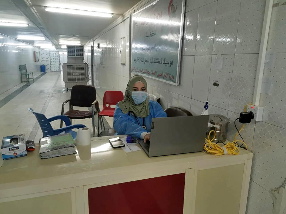 This May 13, 2020, picture provided by Dr. Marwa al-Khafaji shows the doctor back at work following 20 days in isolation after she tested positive for the coronavirus at a hospital in Karbala, Iraq. Dr. Marwa al-Khafaji’s homecoming from a hospital isolation ward was tainted by spite. Someone had barricaded her family home’s gate with a concrete block. The message from the neighbors was clear: She had survived coronavirus, but the stigma of having had the disease would be a more pernicious fight. (AP Photo)