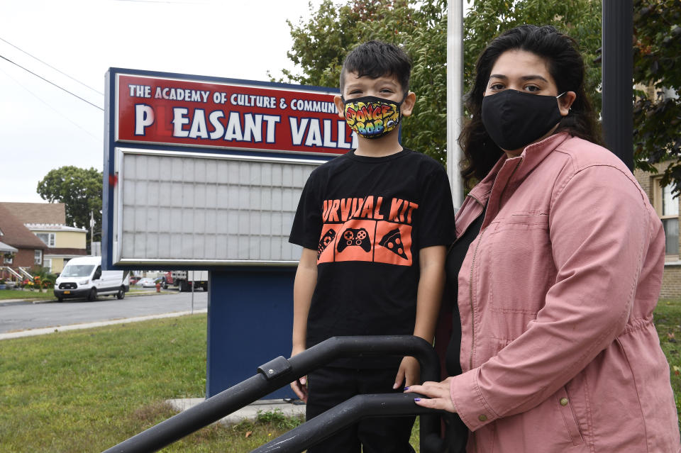 Kristina Negron poses for a photograph with her son, Mason Negron, 6, at his Pleasant Valley Elementary school Tuesday, Sept. 29, 2020, in Schenectady, N.Y. Negron was laid off from her job as an aide for a special education class at Schenectady High School, due to budget cuts. (AP Photo/Hans Pennink)