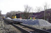 Equipment and gravel pile up along the railroad tracks in downtown East Palestine, Ohio, on Sunday, Feb. 5, 2023. A smoldering tangle of dozens of derailed freight cars, some carrying hazardous materials, has kept an evacuation order in effect in Ohio near the Pennsylvania state line as environmental authorities warily watch air quality monitors. (Lucy Schaly/Pittsburgh Post-Gazette via AP)