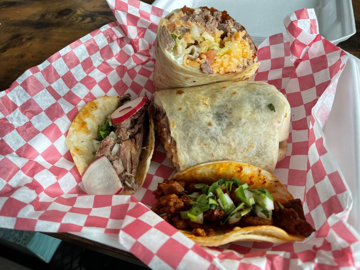 A lengua burrito from Tacos La Familia, flanked by al pastor and barbacoa tacos