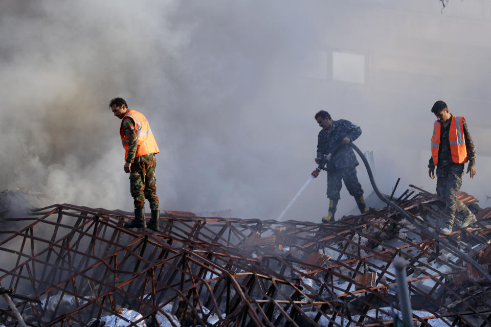 Emergency services work at a destroyed building hit by an air strike in Damascus, Syria, Monday, April 1, 2024. An Israeli airstrike has destroyed the consular section of Iran's embassy in Damascus, killing or wounding everyone inside, Syrian state media said Monday. (AP Photo/Omar Sanadiki)