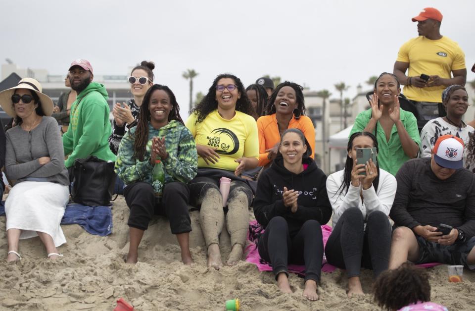 Spectators cheer during a surfing competition at "A Great Day in the Stoke" at Huntington Beach on Saturday.