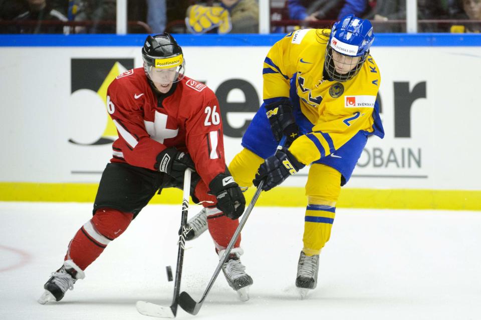 Sweden's Anton Karlsson (R) tries to stop Switzerland's Jason Fuch during their IIHF World Junior Hockey Championship ice hockey game in Malmo December 26, 2013. REUTERS/Ludvig Thunman/TT News Agency (SWEDEN - Tags: SPORT ICE HOCKEY) ATTENTION EDITORS - THIS IMAGE WAS PROVIDED BY A THIRD PARTY. THIS PICTURE IS DISTRIBUTED EXACTLY AS RECEIVED BY REUTERS, AS A SERVICE TO CLIENTS. SWEDEN OUT. NO COMMERCIAL OR EDITORIAL SALES IN SWEDEN. NO COMMERCIAL SALES