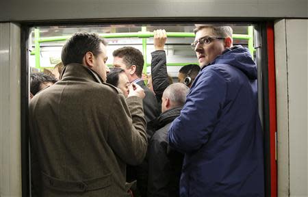 Evening commuters get on to a tube train in central London February 5, 2014. REUTERS/Paul Hackett