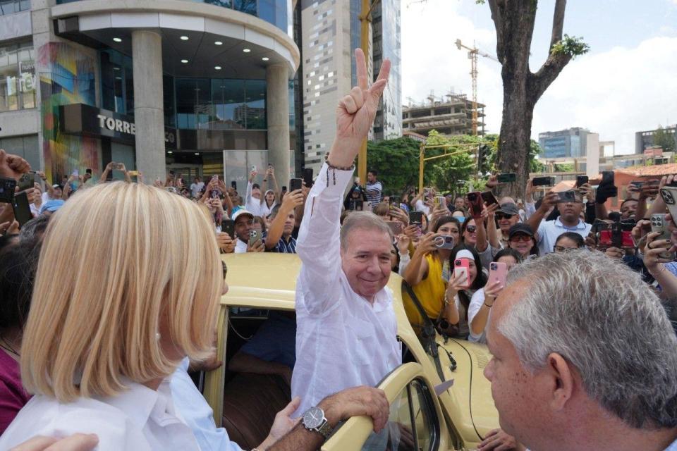 Edmundo González Urrutia desce do seu carro, um fusca amarelo, para ir votar, no meio de uma multidão.