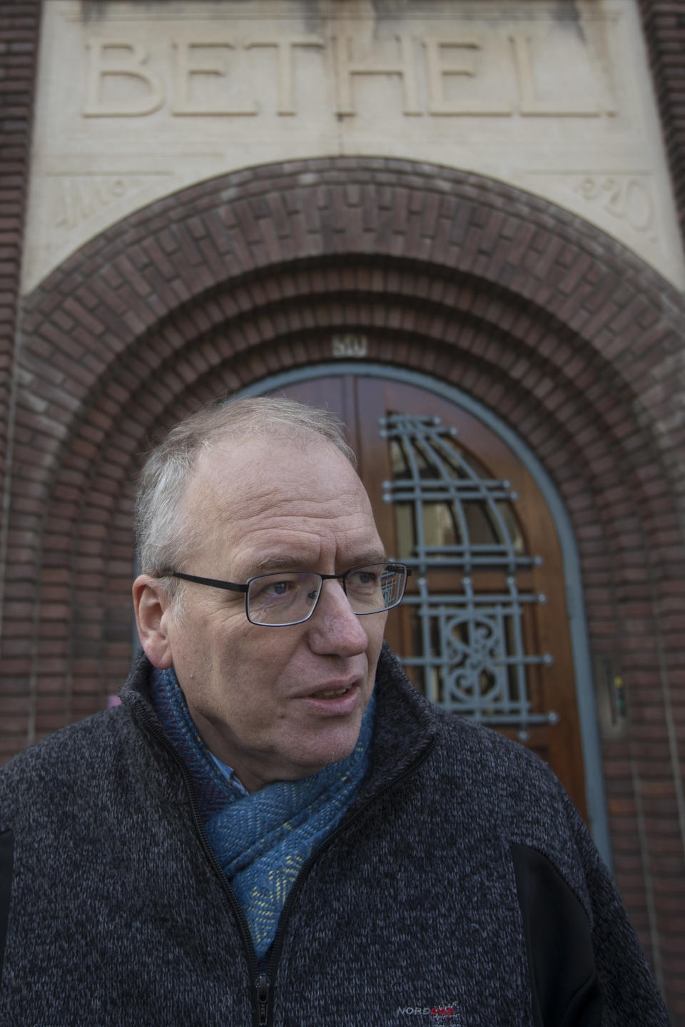 Theo Hettema, chair of the General Council of the Protestant Church of The Hague, answers questions during an interview in front of the Bethel church in The Hague, Netherlands, Friday, Nov. 30, 2018. For more than a month, a rotating roster of preachers and visitors has been leading a non-stop, round-the-clock service at a small Protestant chapel in a quiet residential street in The Hague in an attempt to prevent the deportation of a family of Armenian asylum seekers. (AP Photo/Peter Dejong)