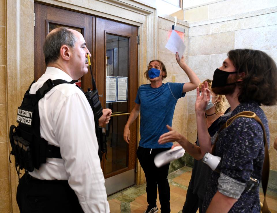 Tom Conley, president and CEO of private security firm Conley Group, argues with John Noble, 26, as Noble demands to know why he and others were being denied access to a Des Moines City Council meeting on June 28.