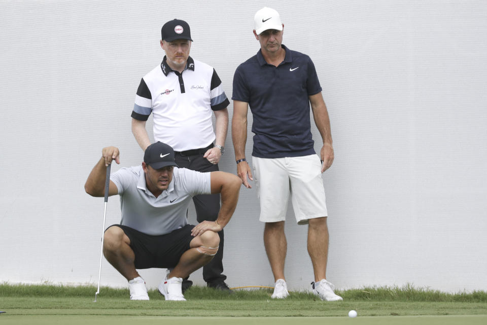 Brooks Koepka, left, lines up a putt on the practice green at the World Golf Championships-FedEx St. Jude Invitational Wednesday, July 29, 2020, in Memphis, Tenn. (AP Photo/Mark Humphrey)