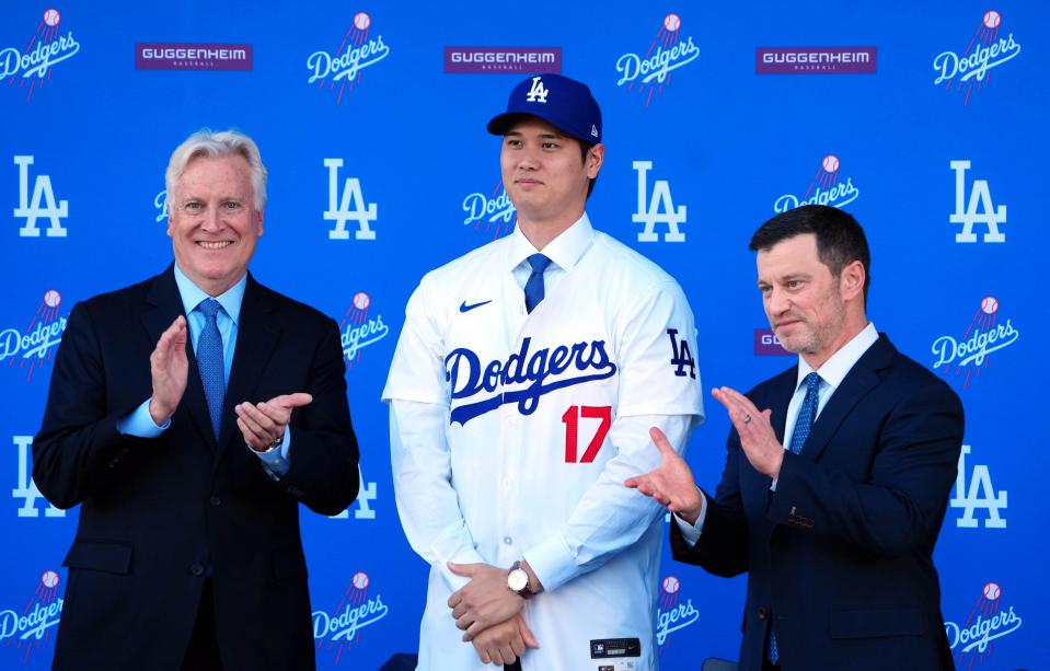 Los Angeles Dodgers owner Mark Walter, left, and president of baseball operations Andrew Friedman introduce Shohei Ohtani during an  introductory press conference at Dodger Stadium on Thursday.