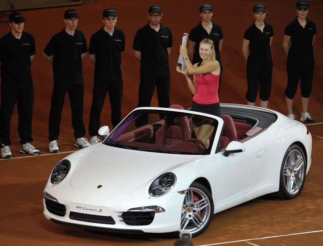 Russia's Maria Sharapova poses for photographers in the winner's prize, a Porsche 911 Carrera, after defeating Belarus` Victoria Azarenka in the final match of the WTA Porsche Tennis Grand Prix in Stuttgart, southwestern Germany, on April 29, 2012. Sharapova won 6-1, 6-4. AFP PHOTO THOMAS KIENZLETHOMAS KIENZLE/AFP/GettyImages