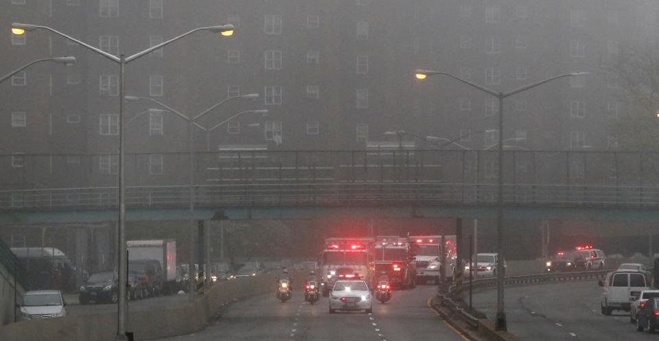 Police and fire department vehicles lead a procession through the fog along Franklin D. Roosevelt East River Drive with the unidentified remains of victims of the Sept. 11, 2001 attacks as they are returned to the World Trade Center site, Saturday, May 10, 2014, in New York. The remains were moved from the Office of the Chief Medical Examiner on Manhattan's East Side at dawn Saturday. The remains will be transferred to an underground repository in the same building as the National September 11 Memorial Museum. (AP Photo/Julio Cortez)