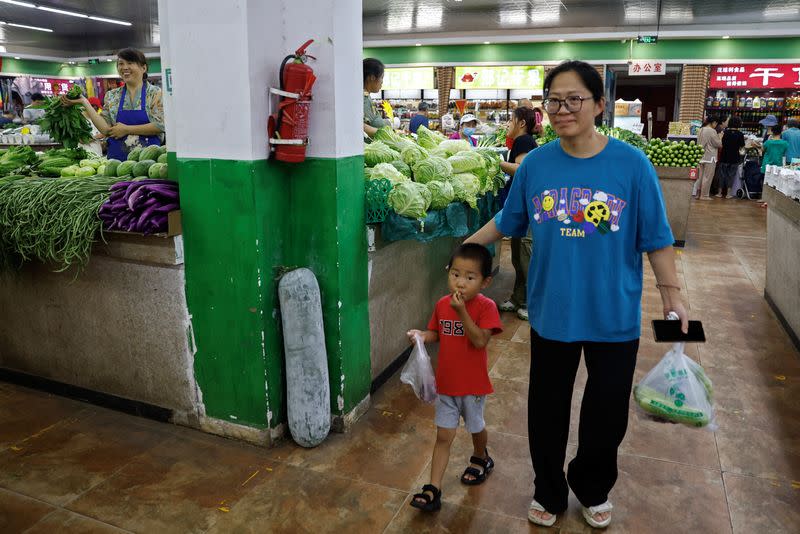 Customers shop for grocery at a morning market in Beijing