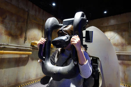 A staff member demonstrates a test-run of the virtual reality (VR) attraction "Explore the Stars", at the Oriental Science Fiction Valley theme park in Guiyang, Guizhou province, China November 16, 2017. REUTERS/Joseph Campbell/Files