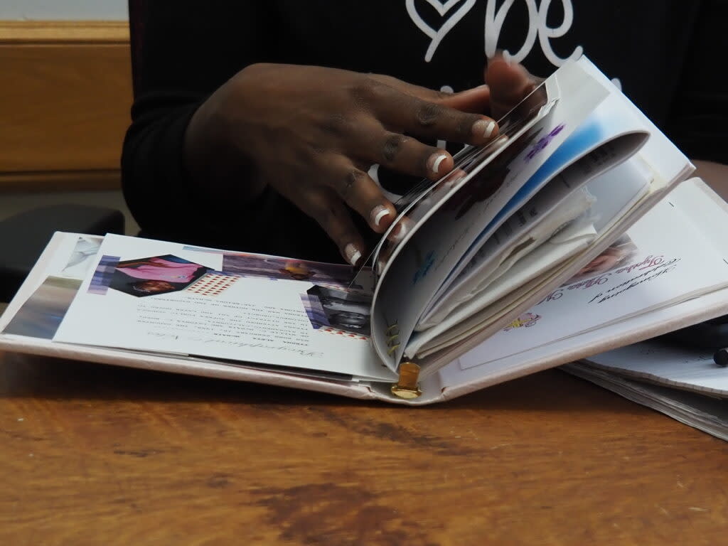 LaRonna Lassiter Saunders, a civil rights advocate and attorney, flips through Tyesha's funeral book. (Rachel Mipro/Kansas Reflector)