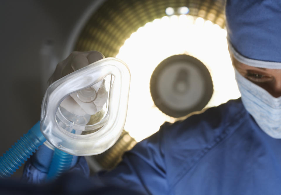 A doctor holding an oxygen mask