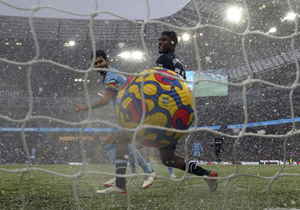 Manchester City's Ilkay Gundogan, left, scores his side's first goal during the English Premier League soccer match between Manchester City and West Ham United at the Etihad stadium in Manchester, England, Sunday, Nov. 28, 2021. (Nick Potts/PA via AP)