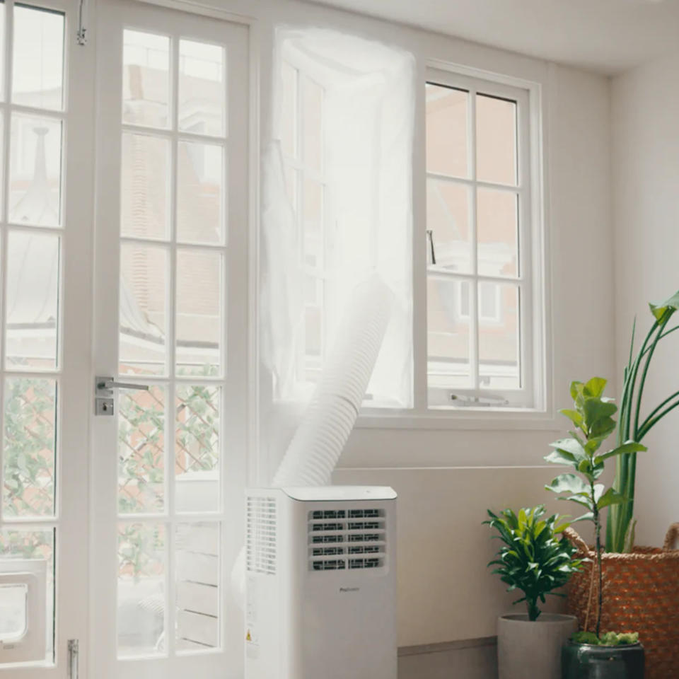 A portable air conditioner being vented out of a window