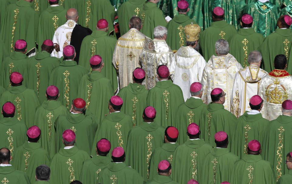FILE - Bishops attend a Mass celebrated by Pope Francis for the opening of a synod, a meeting of bishops, in St. Peter's Square, at the Vatican, Wednesday, Oct. 3, 2018. The synod is bringing together 266 bishops from five continents for talks on helping young people feel called to the church at a time when church marriages and religious vocations are plummeting in much of the West. Pope Francis is convening a global gathering of bishops and laypeople to discuss the future of the Catholic Church, including some hot-button issues that have previously been considered off the table for discussion. Key agenda items include women's role in the church, welcoming LGBTQ+ Catholics and how bishops exercise authority. For the first time, women and laypeople can vote on specific proposals alongside bishops. (AP Photo/Alessandra Tarantino, File)