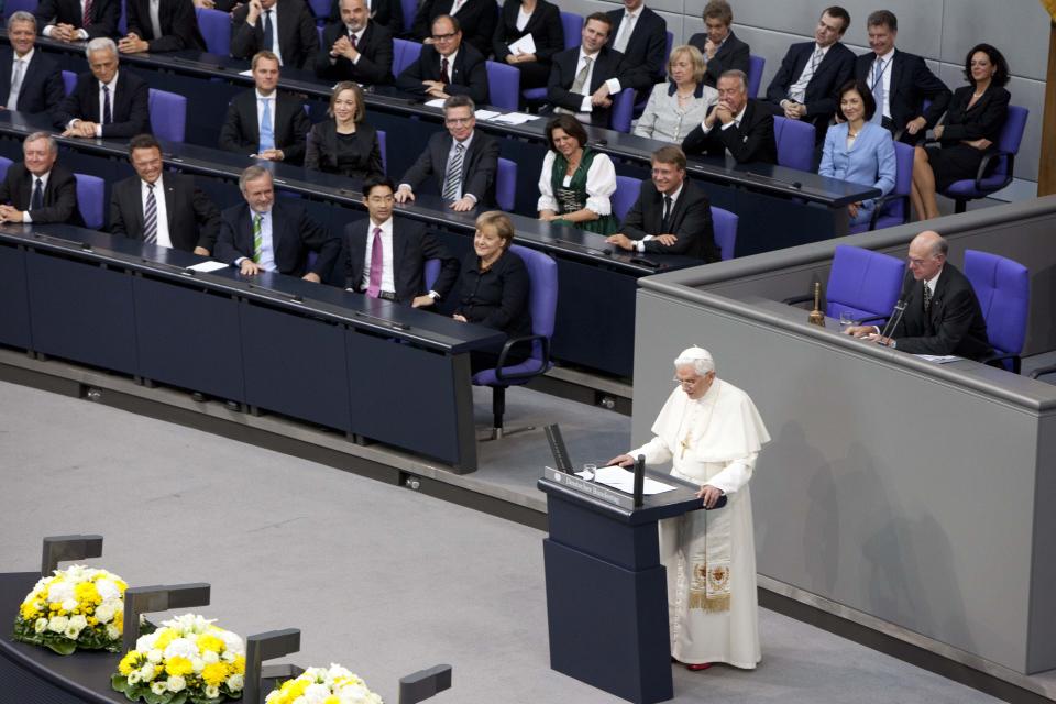 FILE - German Chancellor Angela Merkel, center left, and her government listen to Pope Benedict XVI as he delivers his speech at the German parliament Bundestag in Berlin, Germany, Sept. 22, 2011. Pope Benedict XVI leaves his homeland with a complicated legacy: pride in a German pontiff but a church deeply divided over the need for reforms in the wake of a sexual abuse scandal in which his own actions of decades ago were faulted. (AP Photo/Markus Schreiber, File)