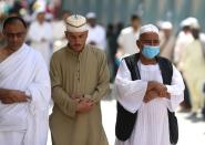 A muslim pilgrim wears a protective face mask to prevent contracting coronavirus, as he prays at the Grand mosque in the holy city of Mecca