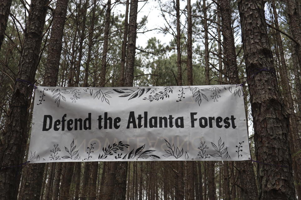 A banner that activists have raised above their main campsite is shown in the South River Forest in DeKalb County, Ga., near the site of a planned police training center on March 9, 2023. Activists have been protesting the center's planned construction for more than a year, derisively calling it "Cop City." (AP Photo/R.J. Rico)