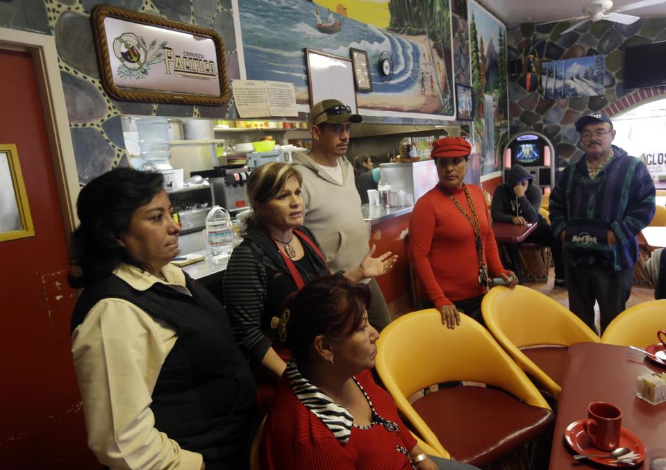 King City residents gather at Veronica Villa's, center with red apron, restaurant to discuss a police car theft ring on Wednesday, Feb. 26, 2014, in King City, Calif. The district attorney charged four police officers and a civilian in a scheme to steal cars from poor Latinos by having their cars impounded at a local tow yard. When the motorists were unable to pay their fees, the tow yard operator sold the cars or gave them for free to police officers. (AP Photo/Marcio Jose Sanchez)