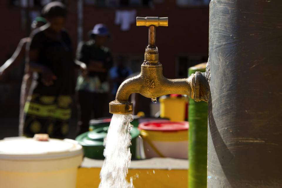 In this April, 24, 2020, photo, water flows from a communal tap that the group Doctors Without Borders provided in a suburb of Harare, Zimbabwe. For people around the world who are affected by war and poverty, the simple act of washing hands is a luxury. In Zimbabwe, clean water is often saved for daily tasks like doing dishes and flushing toilets. (AP Photo/Tsvangirayi Mukwazhi)