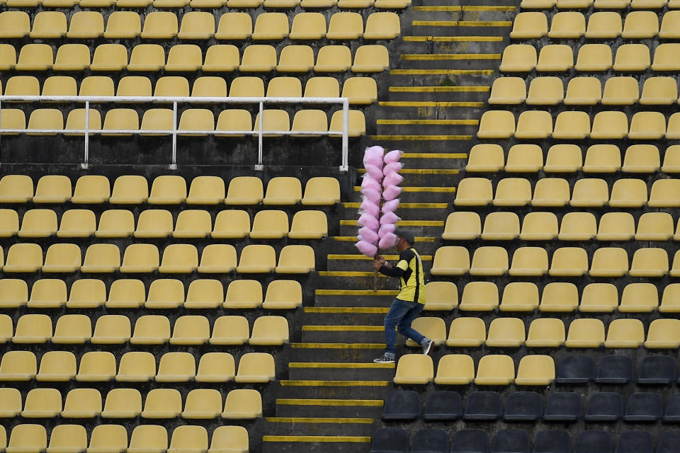 Un vendedor de algodón de azúcar camina por las gradas antes de un juego de la Copa Sudamericana ente el Deportivo Táchira de Venezuela y el Independiente del Valle de Ecuador, en San Cristóbal, Venezuela, el 2 de agosto de 2022. (AP Foto/Matías Delacroix)