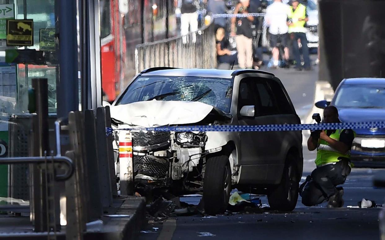 A damaged vehicle is seen at the scene of an incident on Flinders Street, in Melbourne - AAP