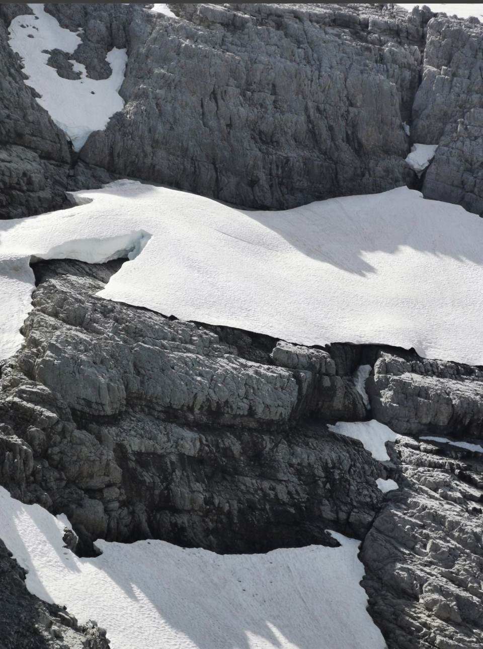 Snow patches on rugged, rocky mountain terrain. No people or text are in the image