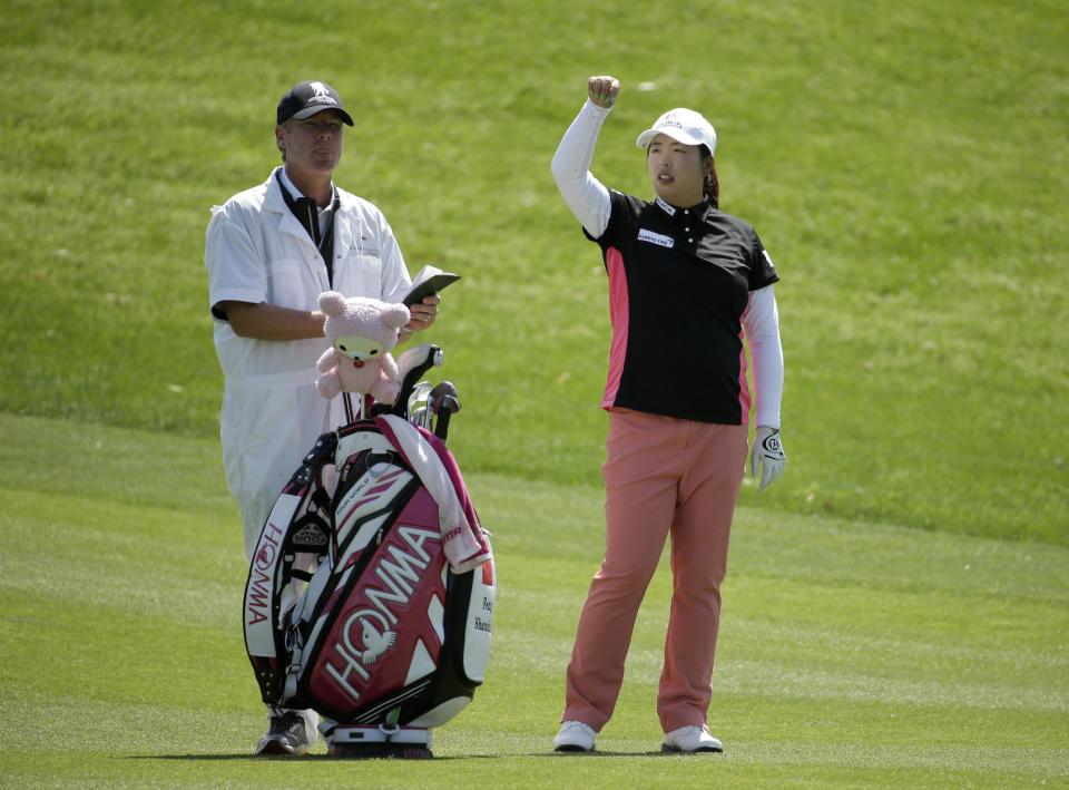 Shanshan Feng, right, of China, checks the wind on the 16th hole during the first round at the Kraft Nabisco Championship golf tournament on Thursday, April 3, 2014, in Rancho Mirage, Calif. (AP Photo/Chris Carlson)