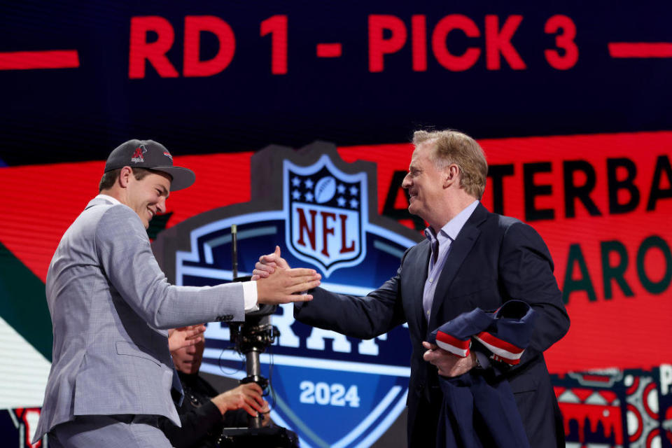 Drake Maye celebrates with NFL Commissioner Roger Goodell after being selected third overall by the New England Patriots during the first round of the 2024 NFL Draft at Campus Martius Park and Hart Plaza on April 25, 2024 in Detroit, Michigan. / Credit: Getty Images