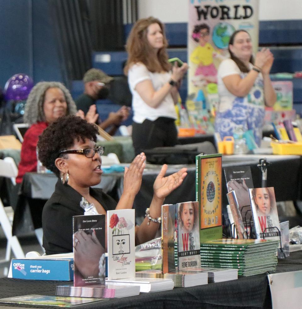 Author Rene Gordon, sitting, foreground, and other attendees applaud during 11th annual Daytona Beach F.R.E.S.H. Book Festival held at the Midtown Cultural & Educational Center in Daytona Beach.