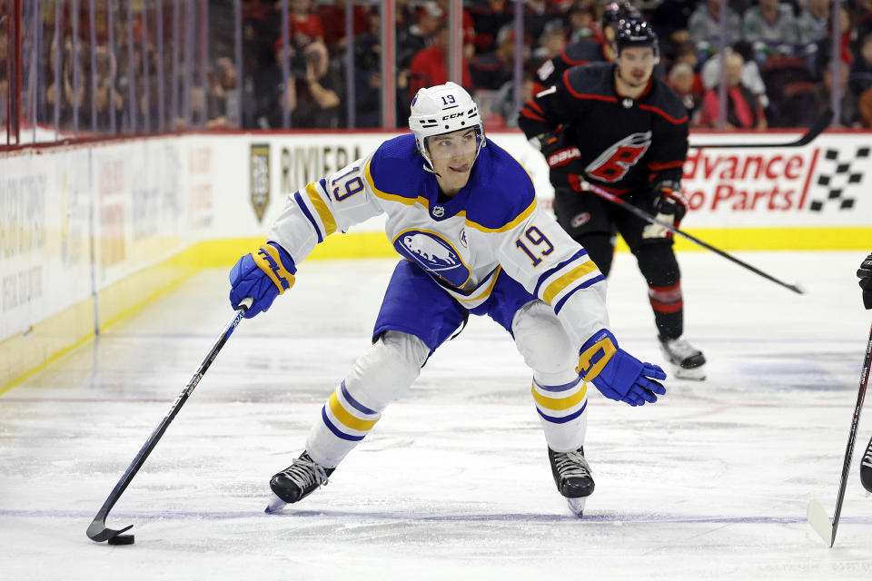 Buffalo Sabres' Peyton Krebs (19) controls the puck with Carolina Hurricanes' Dmitry Orlov (7) looking on during the first period of an NHL hockey game in Raleigh, N.C., Saturday, Dec. 2, 2023. (AP Photo/Karl B DeBlaker)