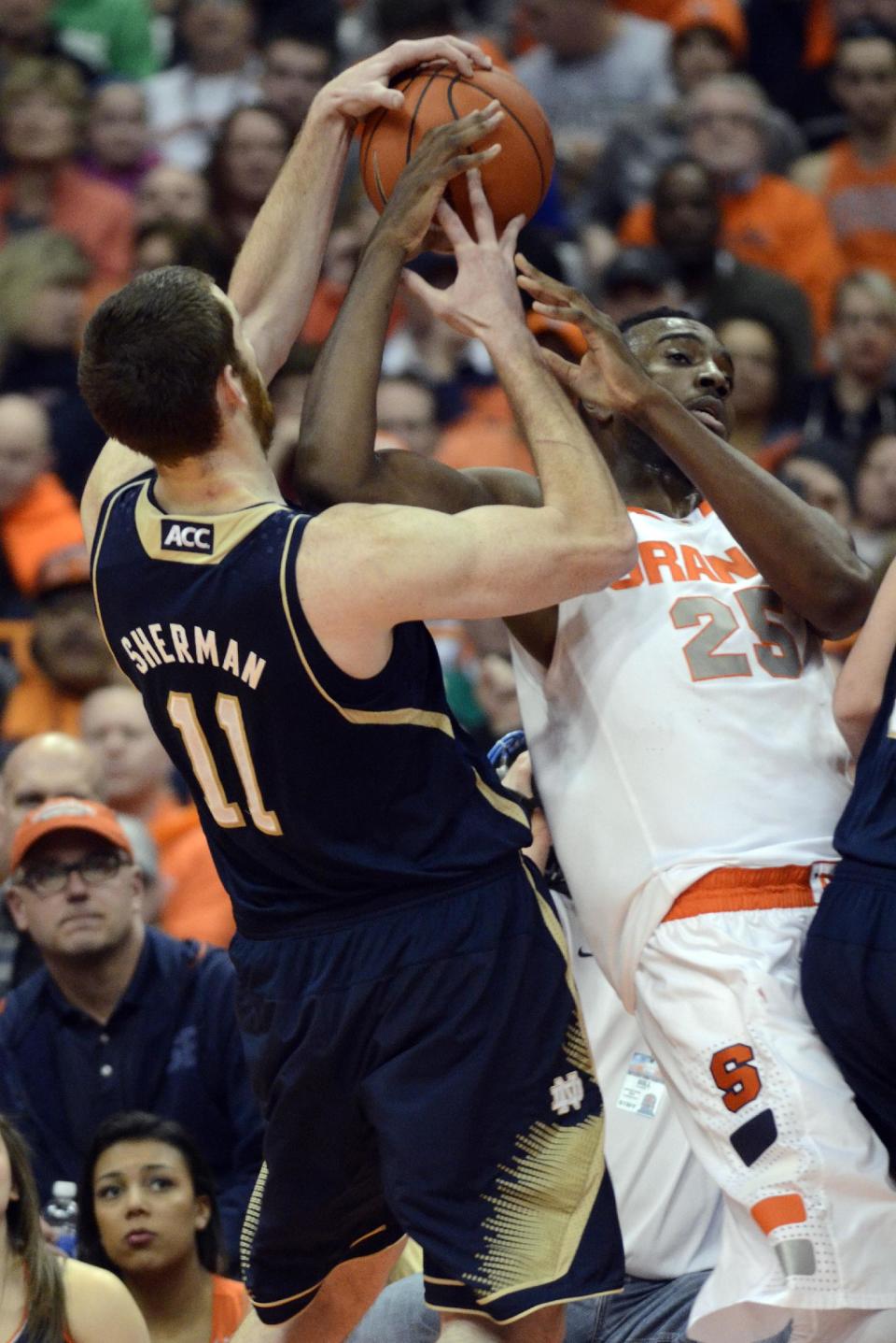 Syracuse's Rakeem Christmas, right, battles Notre Dame's Garrick Sherman for a loose ball during the first half of an NCAA college basketball game in Syracuse, N.Y., Monday, Feb. 3, 2014. (AP Photo/Kevin Rivoli)