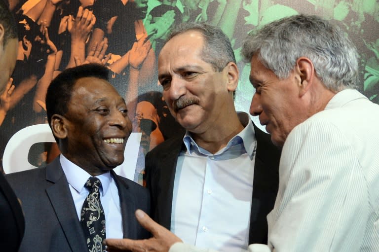 Brazilian football legend Pele (L), Brazilian Minister of Sports Aldo Rebelo (C) and former Brazilian footballer Clodoaldo talk during an exhibition about football in Brasilia on December 17, 2013