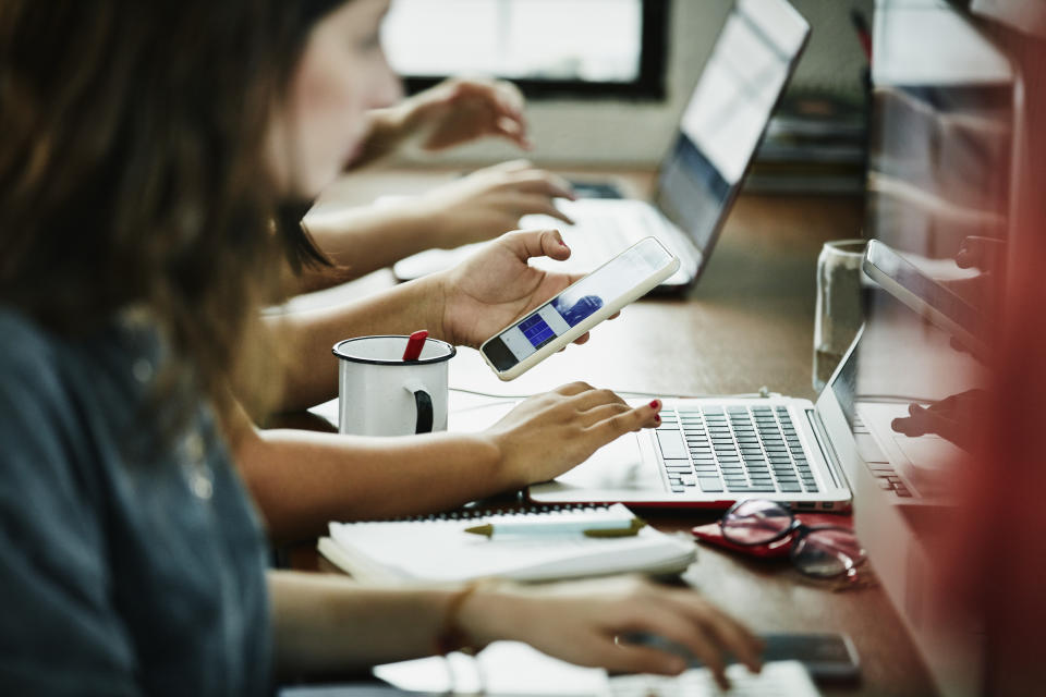 Employees on laptops and phones. 