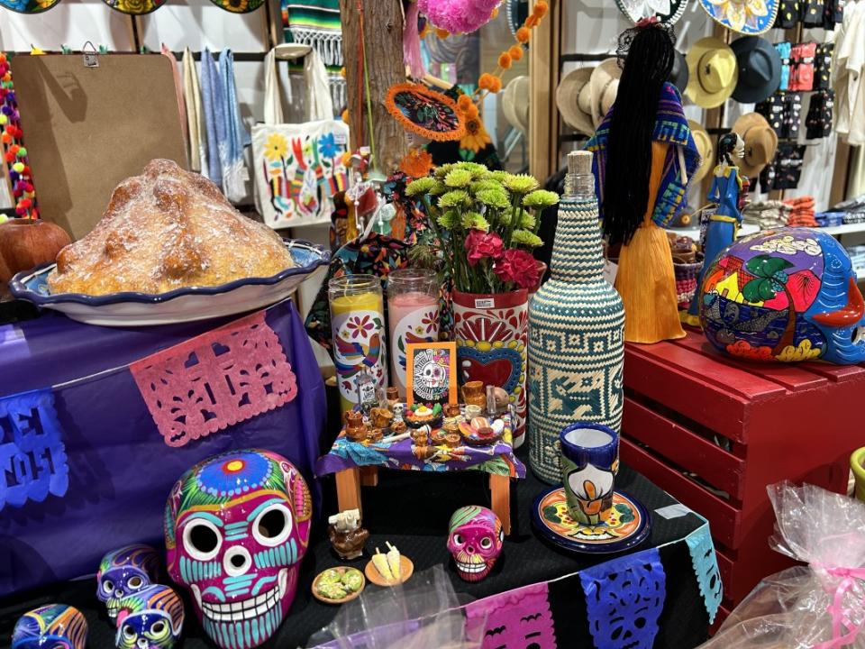 Pan de muerto, alcohol, calaveras and mini food on an ofrenda display at Colores Mexicanos.<p>Alani Vargas/Parade</p>