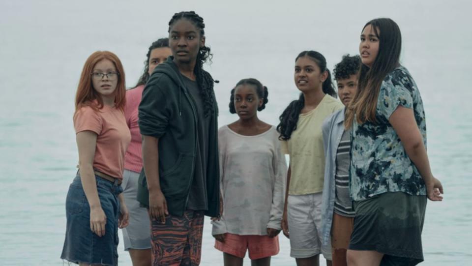 Allie in the power and a group of girls stand together on a beach