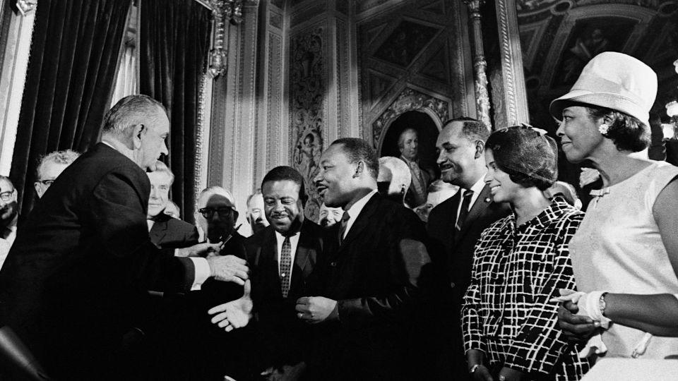 President Lyndon B. Johnson, left, celebrates with Martin Luther King, Jr., Ralph Abernathy, and Clarence Mitchell after signing the Voting Rights Act into law in August 1965. - Corbis/Getty Images