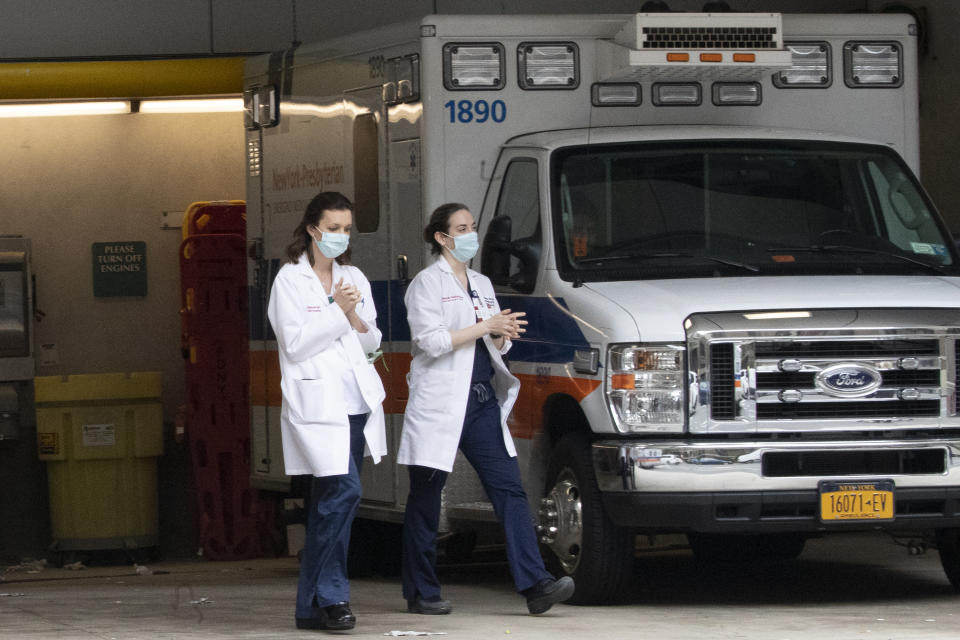 Medical personel rub their hands as they leave the emergency room at New York-Presbyterian Lower Manhattan Hospital on Wednesday, March 18, 2020, in New York. "Do not go to the emergency room unless it is a true, immediate and urgent emergency," said Mayor Bill de Blasio, who pleaded Tuesday with people who suspect they have coronavirus symptoms to stay home and see if they improve in a few days before even calling a doctor. For most people, the new coronavirus causes only mild or moderate symptoms. For some it can cause more severe illness. (Mary Altaffer/AP)