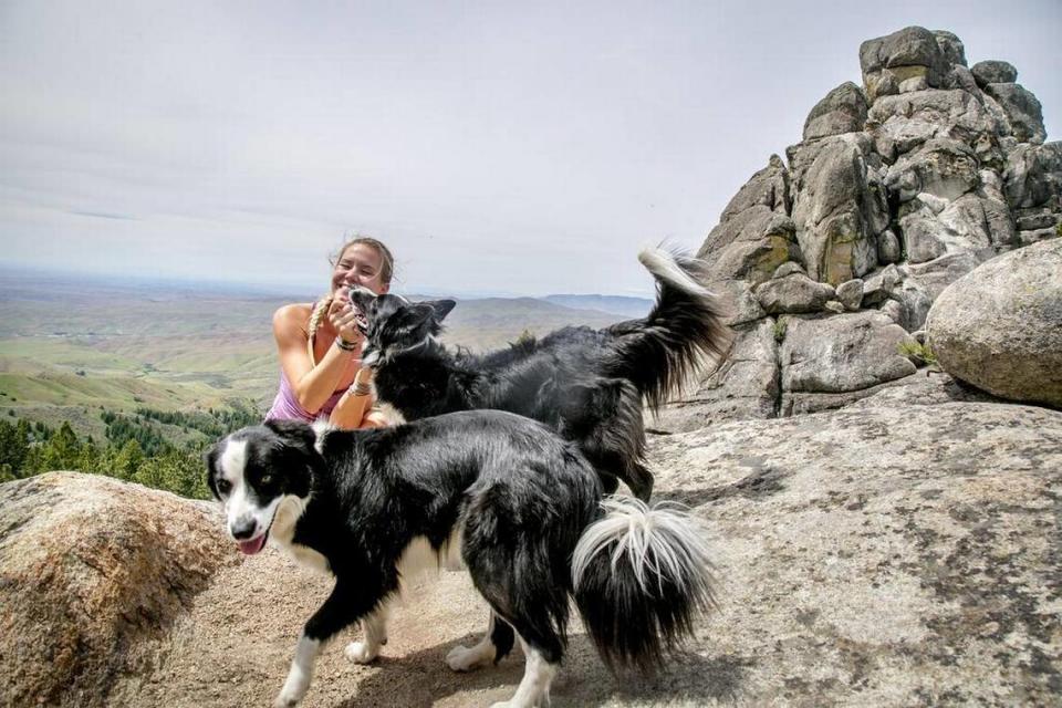 Hiker Sarah Hodge plays with dogs Jango (back) and Mila (front) near Stack Rock. Hodge hiked to Stack Rock for the first time last week. “I loved it,” she said.