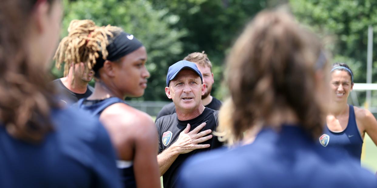 Paul Riley surrounded by North Carolina Courage soccer players.