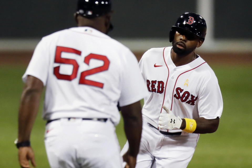 Boston Red Sox's Jackie Bradley Jr. celebrates his two-run home run with third base coach Carlos Febles (52) during the second inning of the team's baseball game against the Toronto Blue Jays, Saturday, Sept. 5, 2020, in Boston. (AP Photo/Michael Dwyer)