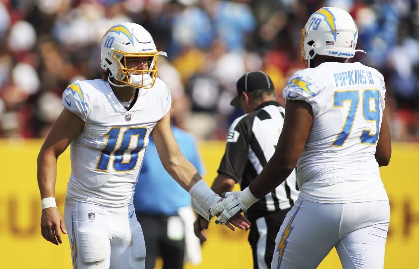 Los Angeles Chargers quarterback Justin Herbert (10) and Los Angeles Chargers offensive tackle Trey Pipkins.