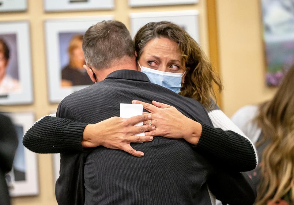 Kadence Koen, a math and business teacher at Southeast High School, hugs Kingsley Keys, a music teacher at Franklin Middle School, after the District 186 School Board voted to pass a “Resolution Authorizing Notice to Remedy” for each of them in their defiance of Gov. JB Pritzker's mandate that school personnel get vaccinated against COVID-19 or get tested weekly during a District 186 School Board meeting at the District 186 Headquarters in Springfield, Ill., Monday, October 18, 2021. [Justin L. Fowler/The State Journal-Register] 