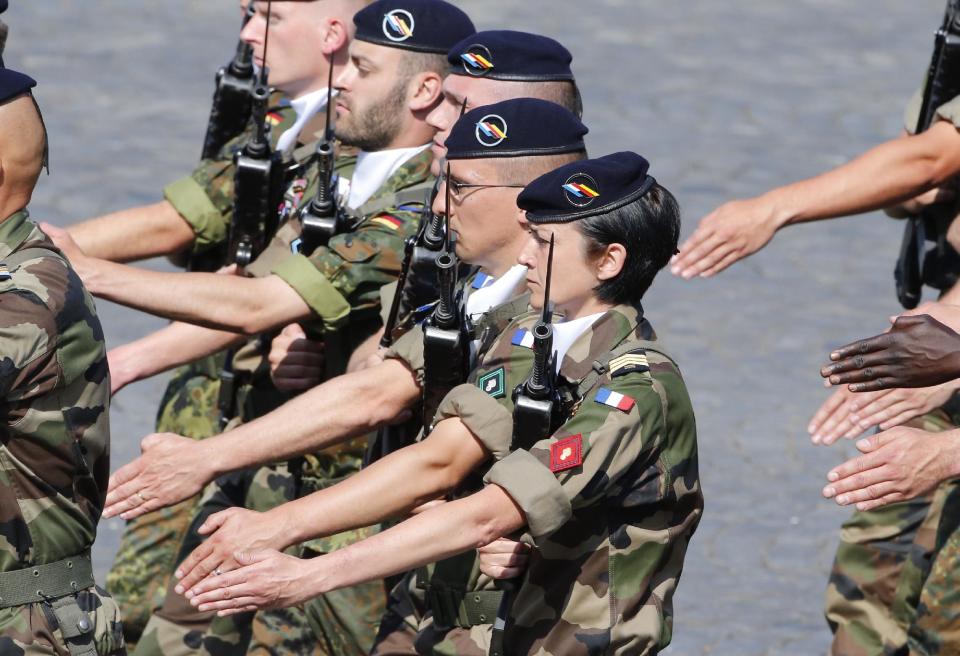 FILE - In this July 14, 2013 file photo, a French female soldier, center, parades with a group of French and German soldiers during the Bastille Day parade in Paris. France claims great success in "feminizing" its military, with among the world’s highest percentages of women in uniform. What it hasn't done is work to prevent sexual assault once they get there. The defense minister on Tuesday April 15, 2014 announced the first plan to address the problem and inflict harsher punishments on those found guilty. (AP Photo/Francois Mori, File)