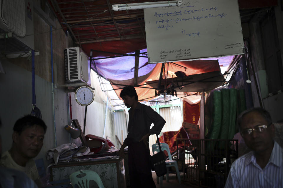 In this Tuesday, Aug. 13, 2013 photo, actors wait in their dimly lit office in downtown Yangon, Myanmar. Each morning, the bad guys of Yangon and their brethren - all members of Ko Lu Chaw, or "Handsome Guy Group," effectively a trade union for cinematic villains - arrive at dawn. They take up position at outdoor breakfast stalls along 35th and 36th streets, a tightly packed enclave of video production houses, movie-poster design studios and worse-for-wear apartment buildings that serves as the tattered ground zero of the Burmese movie industry. Hoping for day work, they order coffee or tea, and they hope. (AP Photo/Wong Maye-E)